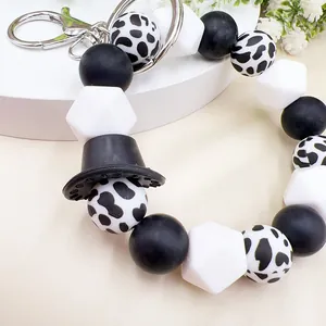 Macro view of Western style cow print silicone bead wristlet keychain with black cowboy hat