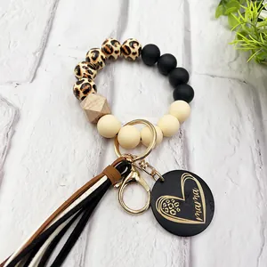 Detail of leopard wood bead silicone wristlet keychain with engraved mama heart charm
