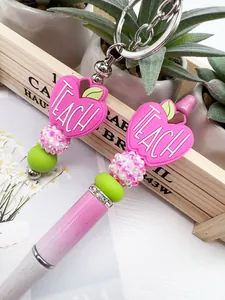 Close-up detail of pink silicone apple bead with TEACH text and rhinestone glitter beads