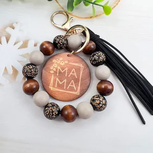 Primer plano de llavero de cuentas de madera con dije MAMA y borla para el Día de la Madre