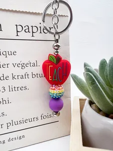 Close-up of a teacher-themed red apple silicone beaded keychain with rainbow accents