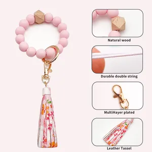 Rosa Silikonperlen-Armband-Schlüsselanhänger mit floraler Lederquaste und Holzperle