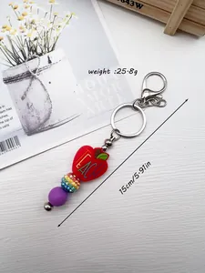 Close-up of teacher apple beaded keychain with rainbow rhinestone and purple silicone beads