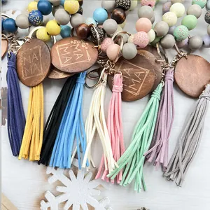 Llavero artesanal de cuentas de madera con borlas de colores y disco MAMA grabado.