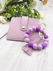 Detail view of a lavender PU leather card holder set with matching silicone bead bracelet.