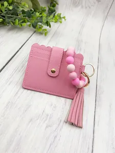 Pink PU leather card holder with silicone bead wristlet and decorative tassel detail