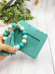 Detail view of silicone bead bracelet with scalloped PU leather card holder and tassel