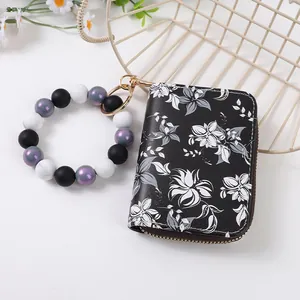 Detailansicht der schwarzen Geldbörse mit Blumenmuster und Silikonperlen-Armband