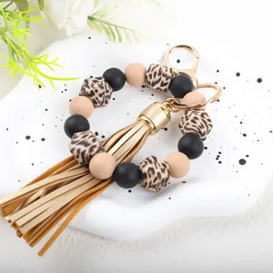 Detailed view of the leopard print beads and beige tassel on this silicone bracelet keychain