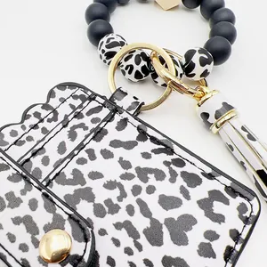 Detalle del tarjetero con el estampado de leopardo, cuentas de silicona y borla.