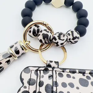 Detalle de porta tarjetas de leopardo con cuentas de silicona y llavero dorado