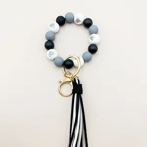 Detailansicht eines Silikonperlen-Armband-Schlüsselanhängers mit schwarz-weißer Quaste.