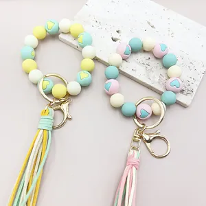 Detailansicht von Pastell-Silikonperlen-Armbändern mit Herzmotiven und Quasten.