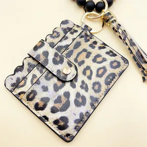 Detalle del portatarjetas de leopardo con pulsera de perlas de silicona y borla.