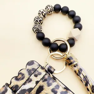 Detalle del tarjetero de leopardo con pulsera de cuentas de silicona negra y leo