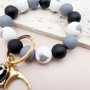 Nahaufnahme eines Schlüsselanhänger-Armbands aus Silikonperlen mit silbernem Herzmuster