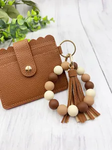 Detailed view of brown PU leather card holder with matching silicone bead tassel keychain