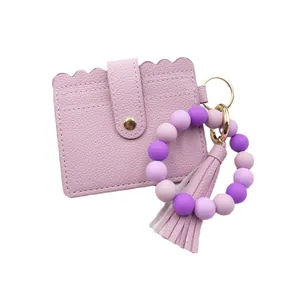 Silicone bead bracelet keychain with purple PU leather card holder and tassel.