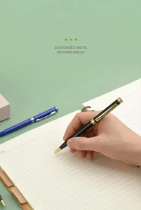 Primer plano de una mano escribiendo con un bolígrafo de metal negro y dorado premium