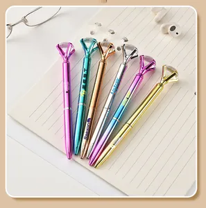 Close-up view of colorful metal ballpoint pens featuring large diamond-shaped crystal tops
