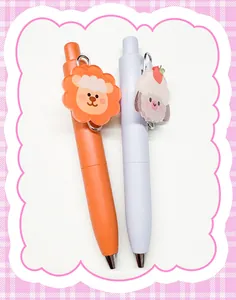 Close-up of mini cartoon gel pens with cute animal acrylic charms in orange and lilac