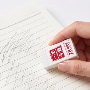 High-quality white 2B professional exam eraser being used on a lined notebook page