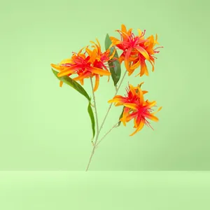 Detail einer 3-köpfigen künstlichen Spinnenlilie mit leuchtend orangeroten Blüten