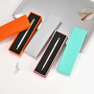 Colorful stationery gift boxes with metallic pens on a minimalist desk setup.