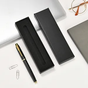 Elegant black pen gift box with a sleek gold-trimmed black ink pen on an office desk.