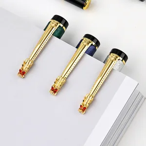 Luxury metal ballpoint pens with gold dragon clip and glitter finish on notebook