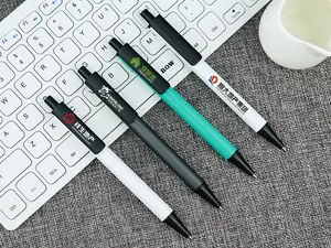 Close-up of customizable business metal retractable pens featuring various printed company logos