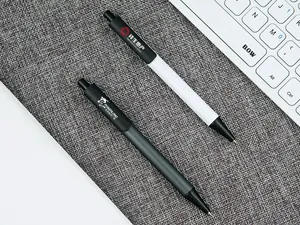Detail view of black and white retractable metal pens with custom logo printing on fabric