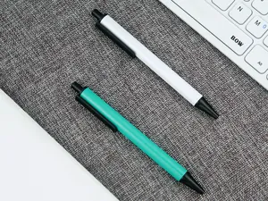 Close-up of white and teal retractable metal pens on textured gray surface