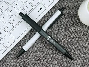 Close-up of premium black and white metal retractable pens with custom logo printing