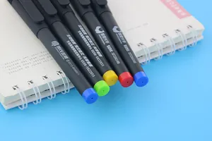 Detailed close-up of customized black gel pens with colorful tail caps on a notebook.