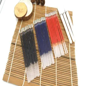 Set of 0.5mm black, blue, and red gel pen refills with white barrels on bamboo mat