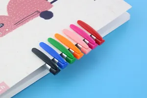 Detail shot of vibrant rainbow colored pen clips attached to a minimalist notebook cover.