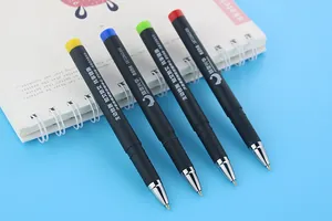 Close-up detail of four custom promotional gel pens with colored caps on a notebook.