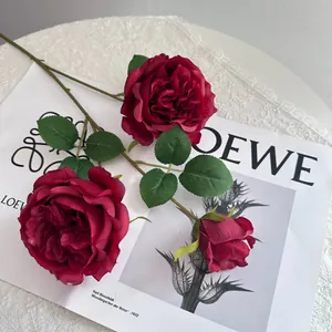 Macro view of deep red artificial Austin rose petals and detailed green foliage.