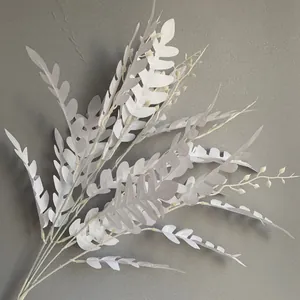 Gedetailleerd overzicht van witte kunstmatige acacia-bladeren voor bruiloftdecor.
