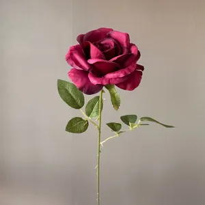 Detaillierte Nahaufnahme einer dunkelmagentafarbenen künstlichen Rose mit grünem Stiel.