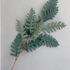 Detail van kunstmatige groene varenbladeren met textuur op effen achtergrond