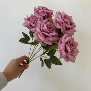 Close-up view of a realistic dusty pink 9-head artificial rose bouquet held by hand