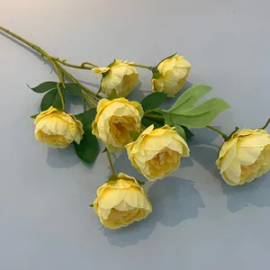 Dettaglio di peonie gialle artigianali a 7 teste con petali e fogliame realistici.