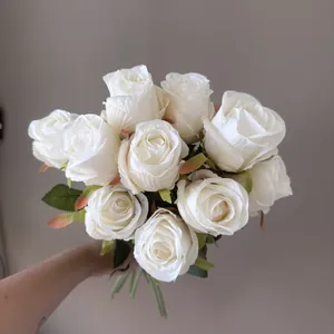 Elegant white Bulgarian artificial roses bouquet held by hand for decoration