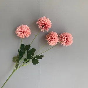Detailed view of pink artificial pompom chrysanthemum flowers with realistic green leaves