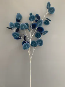 Gedetailleerd overzicht van kunstmatige diepblauwe eucalyptusbladeren aan een witte taksteel
