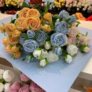 Close-up of artificial three-headed roses in blue, orange, pink, and white silk.