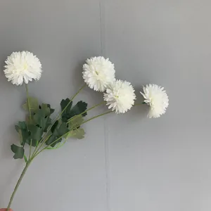 Close-up detail of 4-headed artificial white chrysanthemum with realistic green leaves