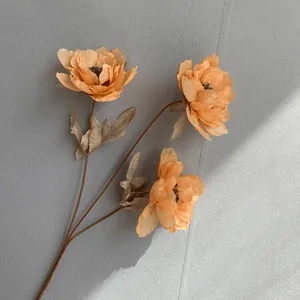Close-up of three-headed artificial apricot peony flower with realistic petal texture